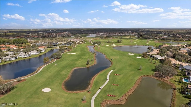 drone / aerial view featuring golf course view and a water view