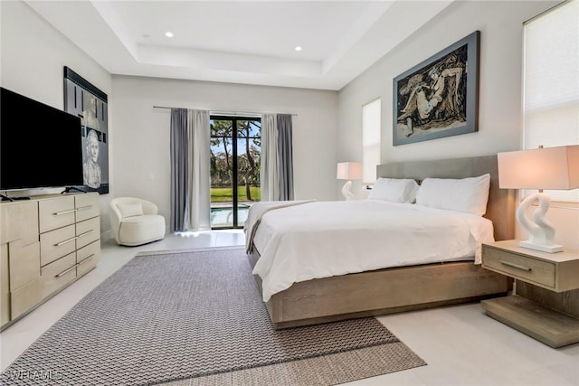 bedroom with a raised ceiling and access to exterior