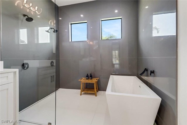 bathroom featuring independent shower and bath, tile walls, and vanity