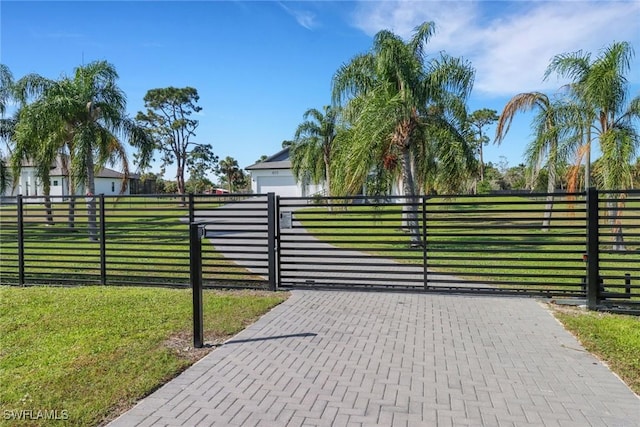 view of gate with a lawn