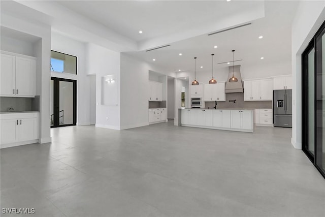 unfurnished living room with sink and a high ceiling