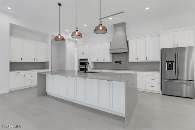 kitchen featuring appliances with stainless steel finishes, decorative light fixtures, white cabinetry, and custom range hood