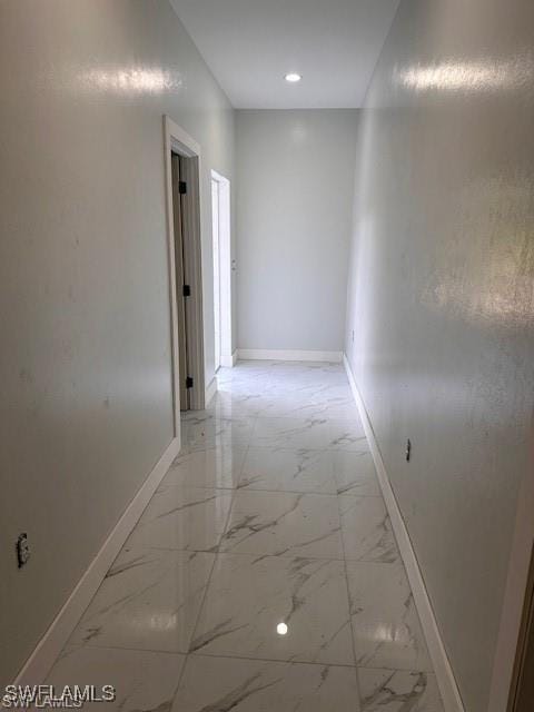 corridor featuring marble finish floor, baseboards, and recessed lighting