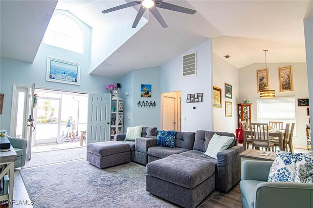 living room featuring hardwood / wood-style flooring, ceiling fan, and high vaulted ceiling