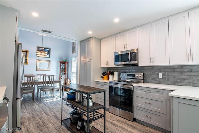 kitchen featuring gray cabinets, stainless steel appliances, and decorative backsplash