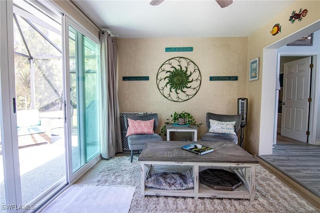 sitting room with wood finished floors and a ceiling fan