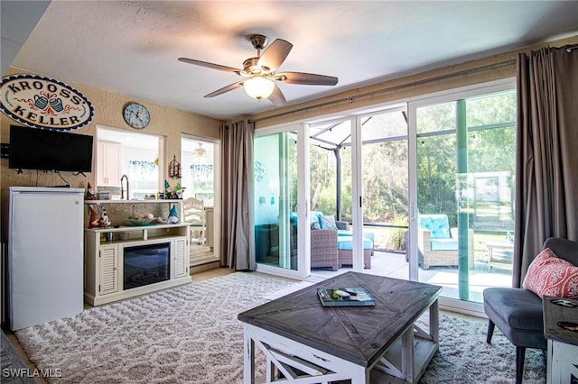 living room with a healthy amount of sunlight, a sunroom, and a ceiling fan