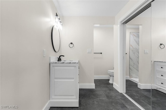 full bathroom featuring a stall shower, toilet, vanity, and baseboards