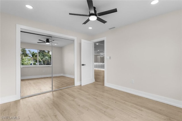 unfurnished bedroom featuring ceiling fan, a closet, and light wood-type flooring