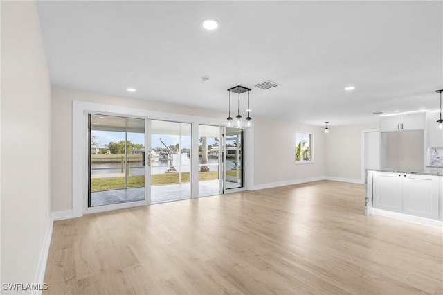 interior space with baseboards, light wood-style flooring, and recessed lighting