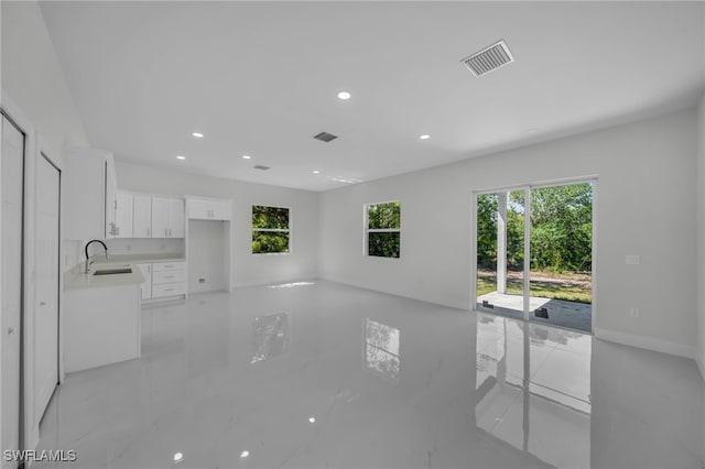 unfurnished living room with a sink and recessed lighting