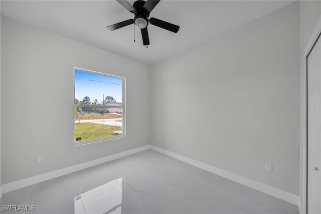 spare room featuring baseboards, marble finish flooring, and a ceiling fan