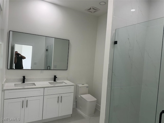 bathroom with a marble finish shower, toilet, and double vanity