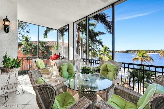 sunroom featuring a water view