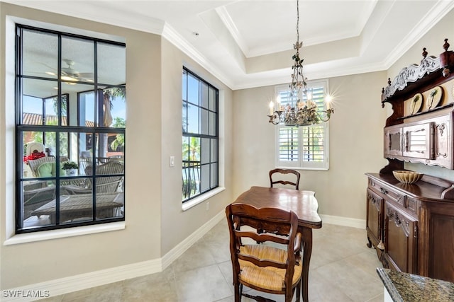 tiled dining room featuring crown molding, a tray ceiling, and an inviting chandelier