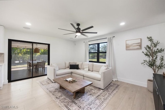 living room featuring ceiling fan and light wood-type flooring