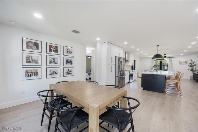 dining area with sink and light wood-type flooring