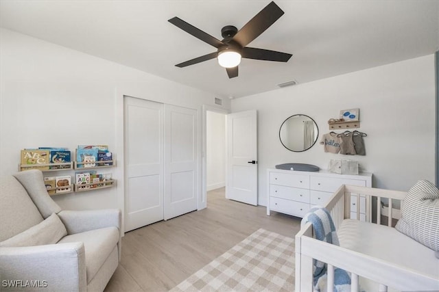 bedroom with a closet, ceiling fan, and light wood-type flooring