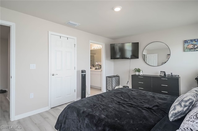 bedroom featuring ensuite bathroom and light wood-type flooring