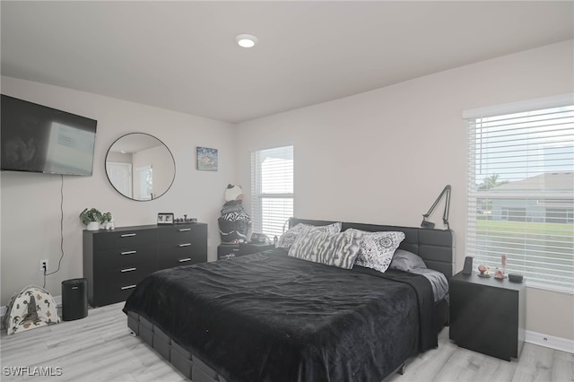 bedroom featuring multiple windows and light wood-type flooring