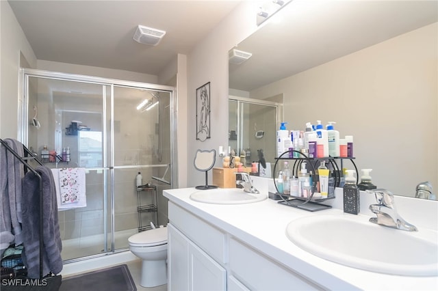 bathroom featuring vanity, toilet, and an enclosed shower