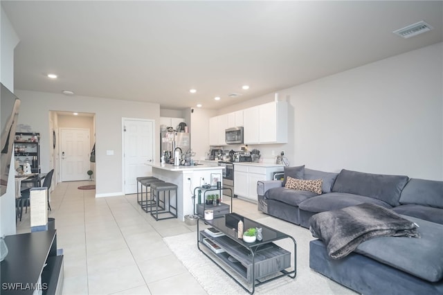 living room featuring sink and light tile patterned floors