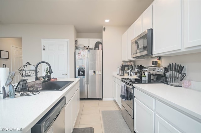 kitchen with white cabinetry, sink, stainless steel appliances, and light tile patterned flooring