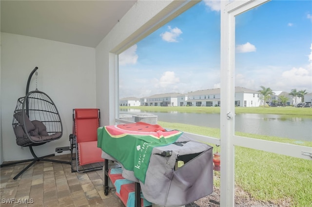 sunroom / solarium with a water view and a healthy amount of sunlight