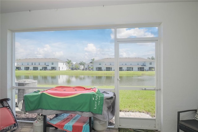 sunroom featuring a water view and a wealth of natural light