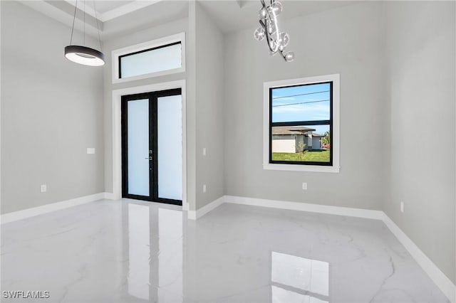 entrance foyer featuring a notable chandelier and french doors