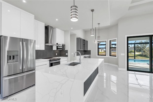 kitchen featuring wall chimney exhaust hood, stainless steel appliances, backsplash, and pendant lighting