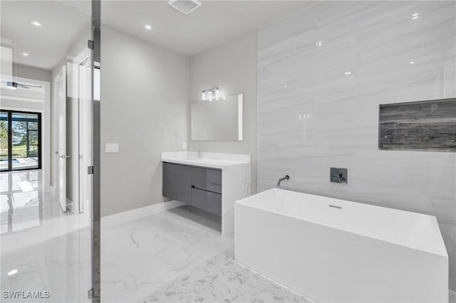 bathroom featuring vanity, tile walls, and a tub