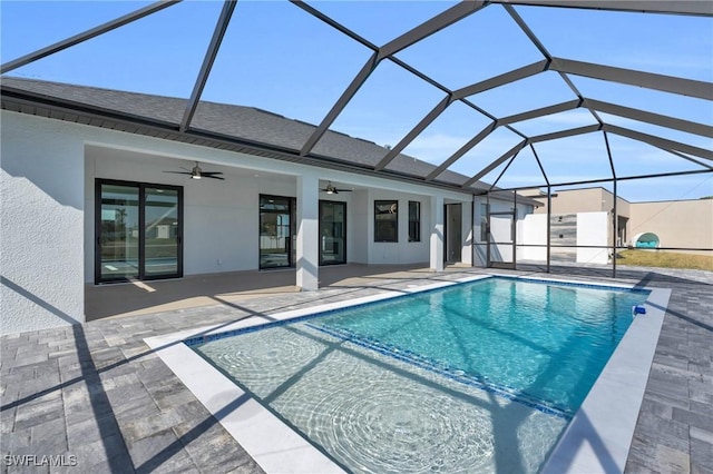 view of pool with a patio area, ceiling fan, and glass enclosure