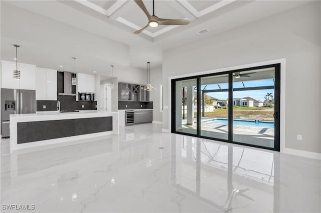 unfurnished living room with coffered ceiling, sink, and ceiling fan