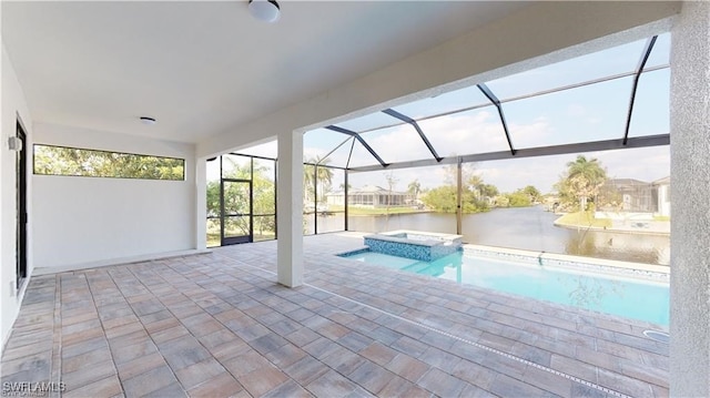 view of swimming pool with an in ground hot tub, a water view, glass enclosure, and a patio