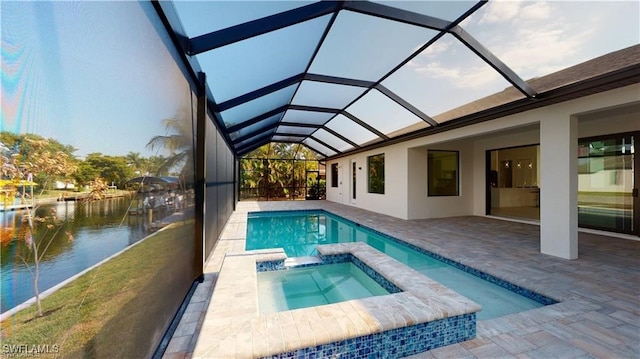 view of pool with an in ground hot tub, a water view, glass enclosure, and a patio area