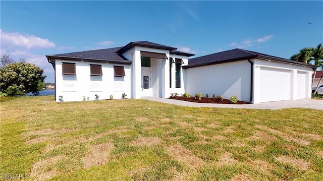 prairie-style home featuring a garage and a front lawn