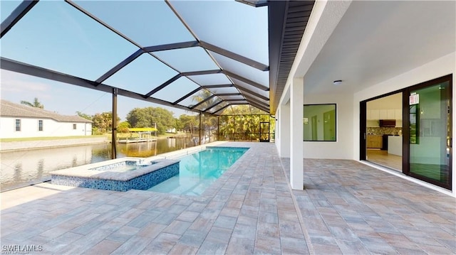 view of pool featuring an in ground hot tub, a water view, glass enclosure, and a patio area