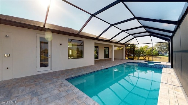 view of pool with an in ground hot tub, a patio, and glass enclosure