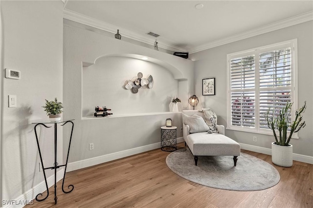 sitting room featuring hardwood / wood-style flooring and ornamental molding