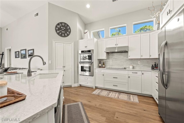 kitchen featuring sink, light hardwood / wood-style flooring, stainless steel appliances, and white cabinets