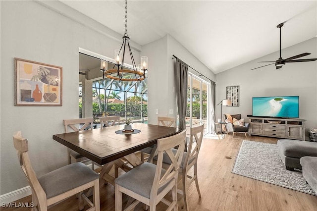 dining area with vaulted ceiling, ceiling fan with notable chandelier, and light hardwood / wood-style floors