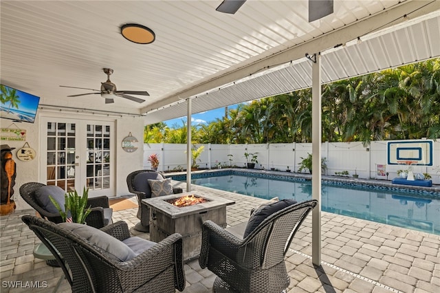 view of pool featuring french doors, ceiling fan, an outdoor fire pit, and a patio area