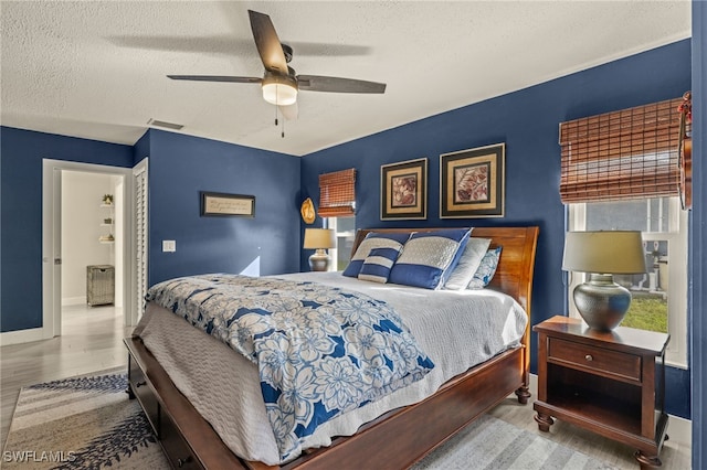 bedroom featuring ceiling fan, hardwood / wood-style flooring, a closet, and a textured ceiling