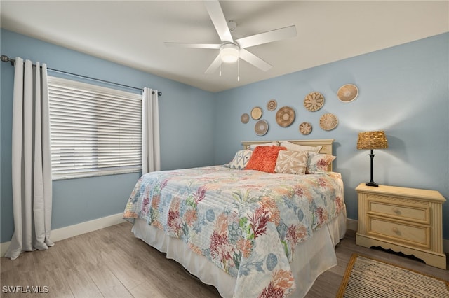 bedroom featuring a ceiling fan, light wood-type flooring, and baseboards