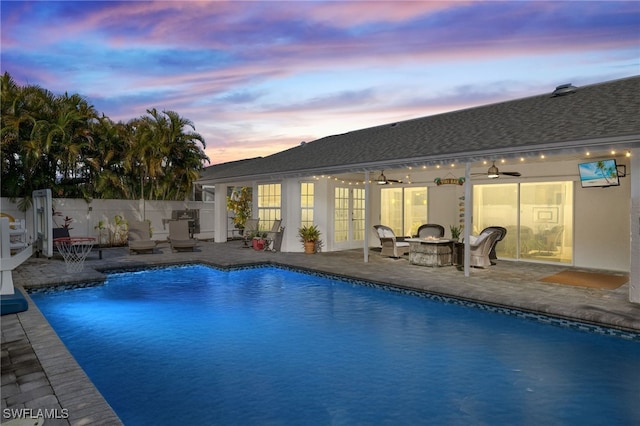 view of swimming pool featuring ceiling fan and a patio