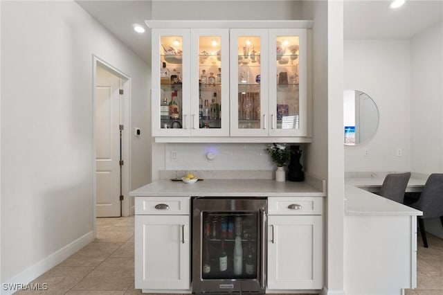 bar featuring tasteful backsplash, white cabinetry, light tile patterned floors, and wine cooler