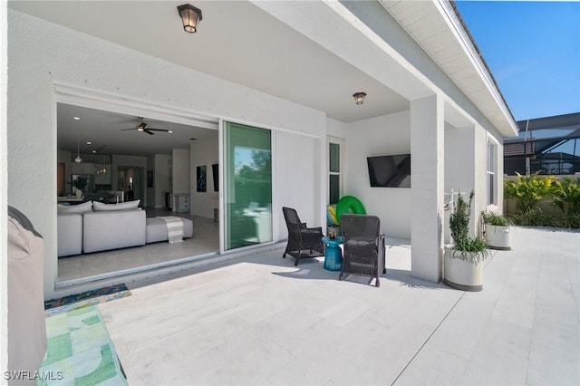 view of patio with an outdoor living space, a lanai, and ceiling fan