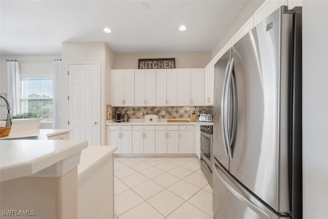 kitchen with sink, light tile patterned floors, appliances with stainless steel finishes, decorative backsplash, and white cabinets