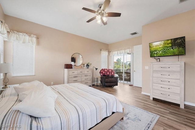 bedroom with ceiling fan, access to outside, and wood-type flooring